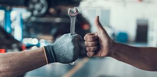 Werkstattarbeiter zeigt Daumen hoch – Tipps zu Reifenwechsel, Montage und Pflege